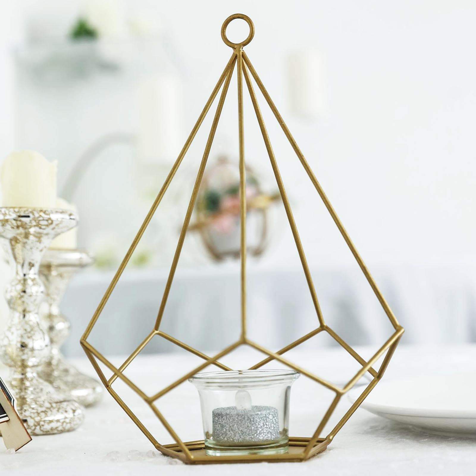 Gold metal pentagon tealight candle holder in geometric open frame design.