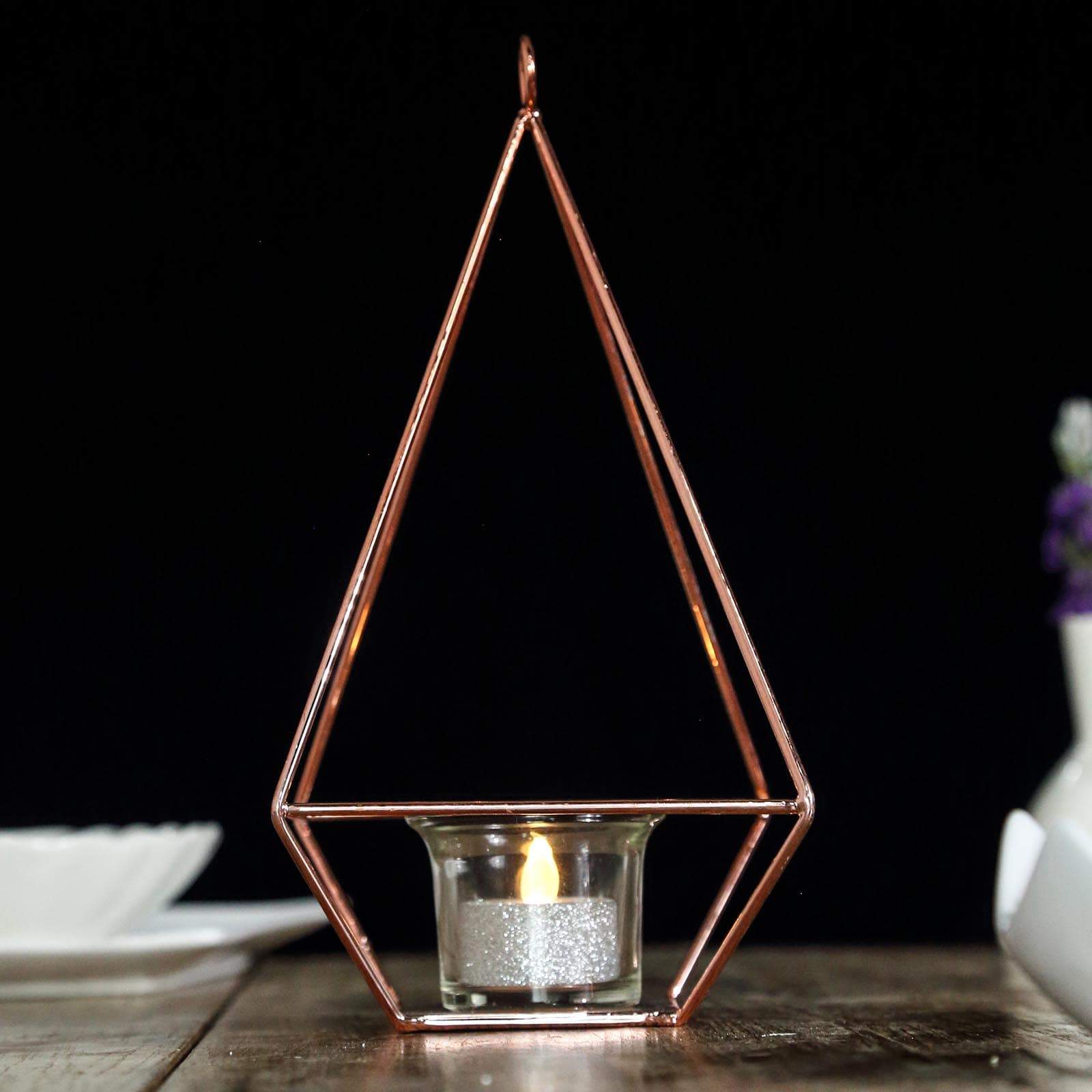 Rose gold geometric candle holder with tealight candle inside.