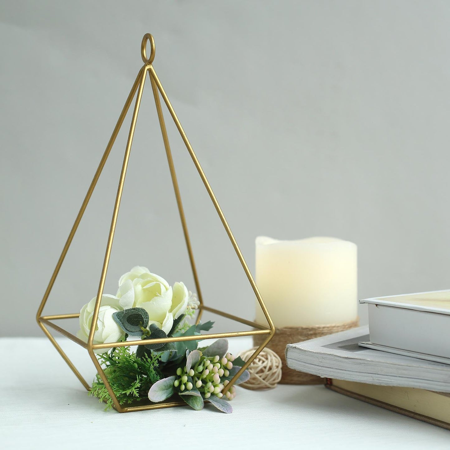 Gold metal pyramid tealight candle holders with geometric design.