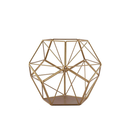 Gold metal pentagon prism tealight candle holder in geometric design.