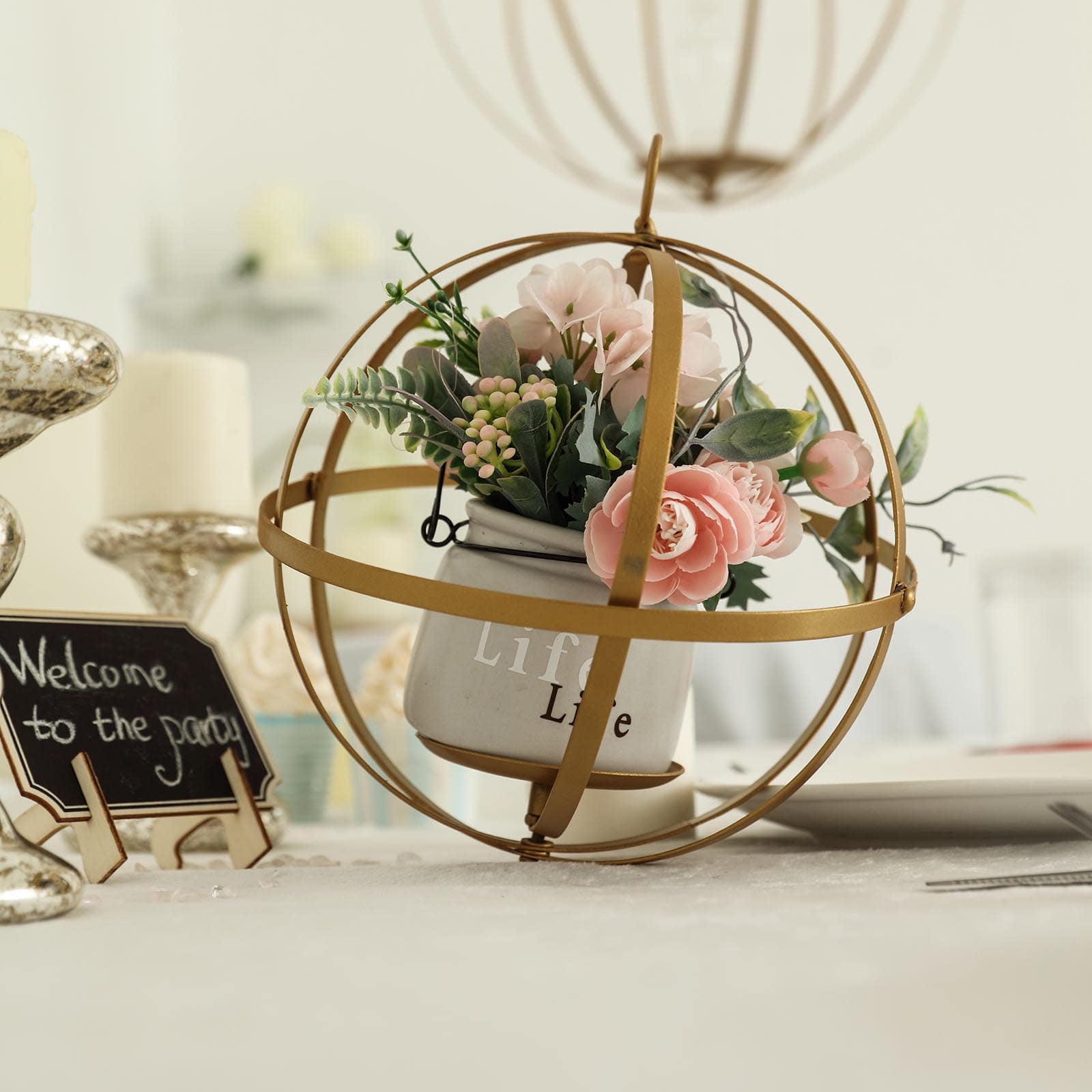 Gold wrought iron centerpiece ball with flowers in a decorative hanging sphere.