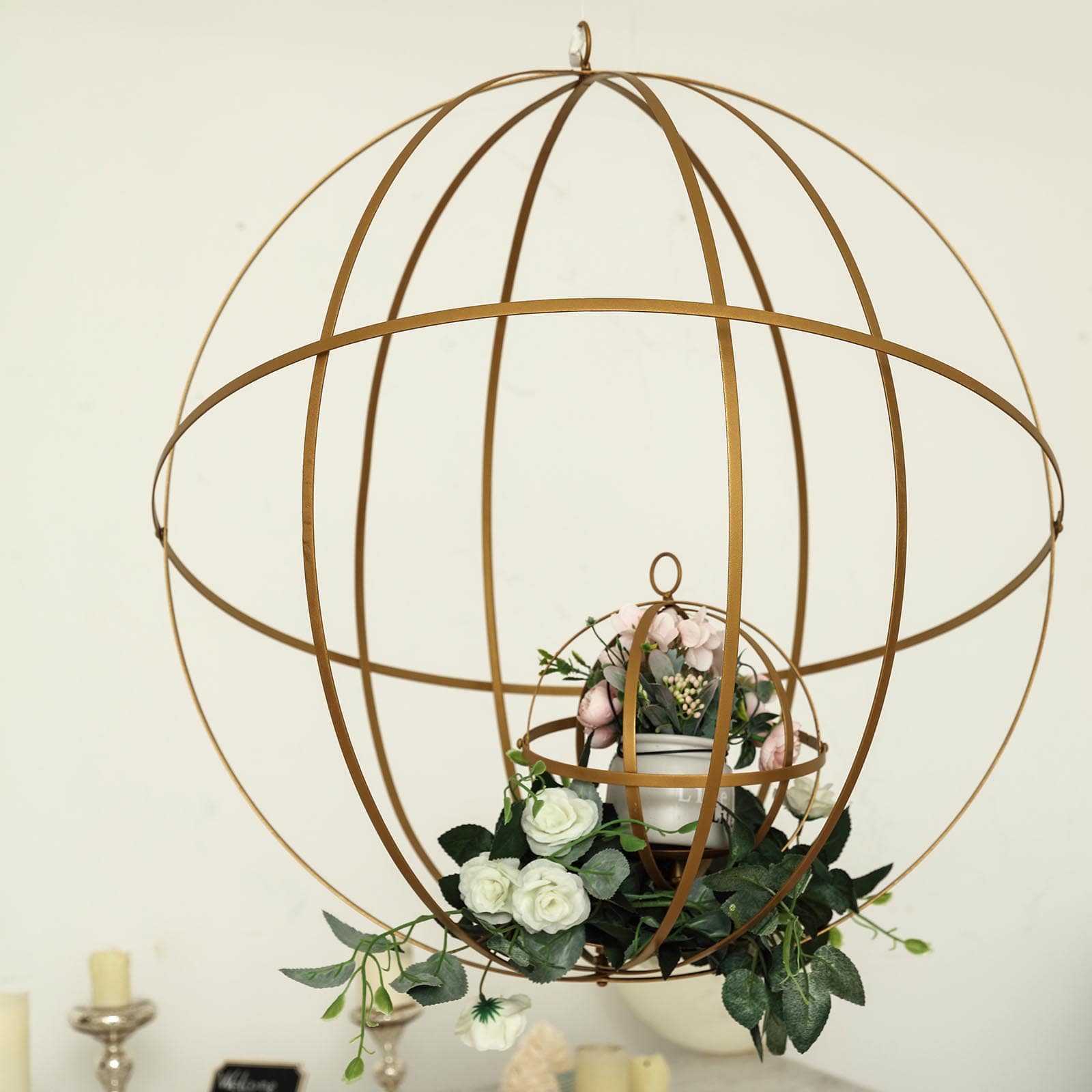 Gold wrought iron open frame centerpiece ball with floral display.