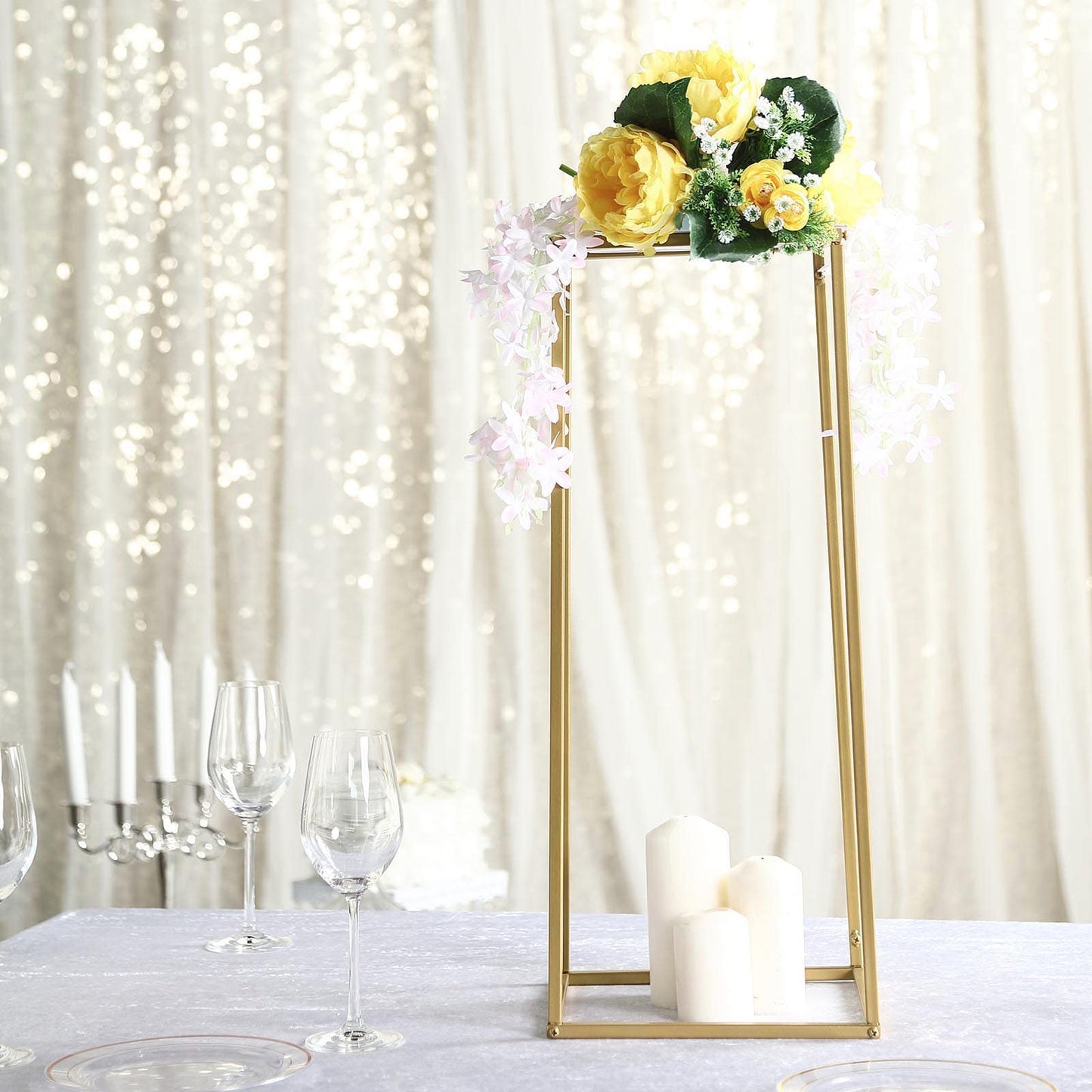 Gold rectangular flower stand centerpiece with floral arrangement.