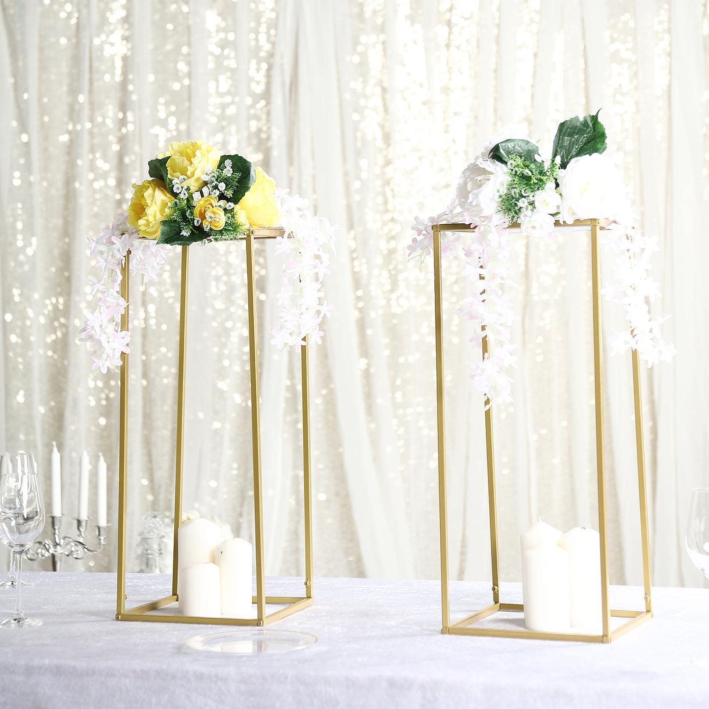 Gold metal geometric wedding flower stands with floral arrangements.