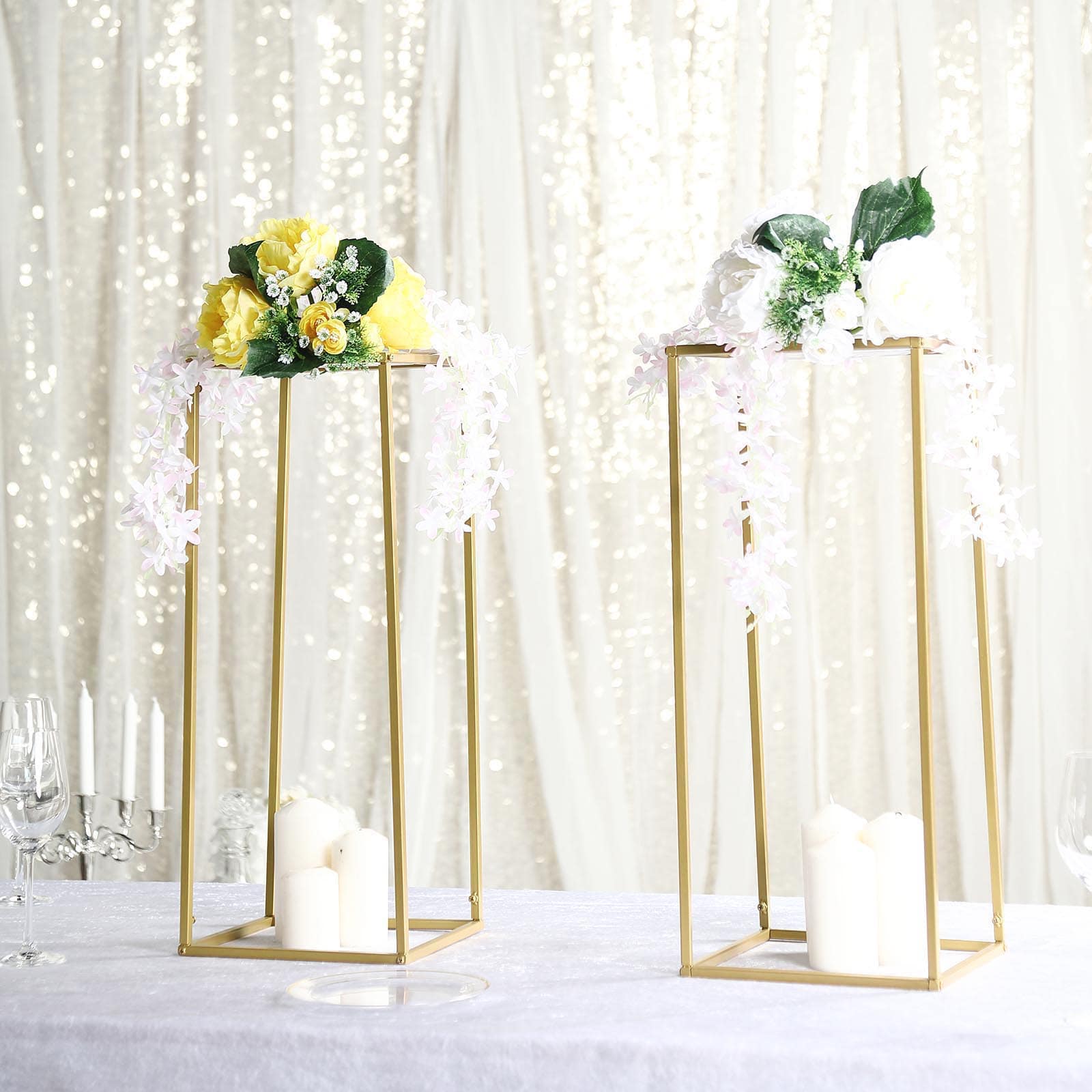 Gold metal geometric wedding flower stands with floral arrangements.
