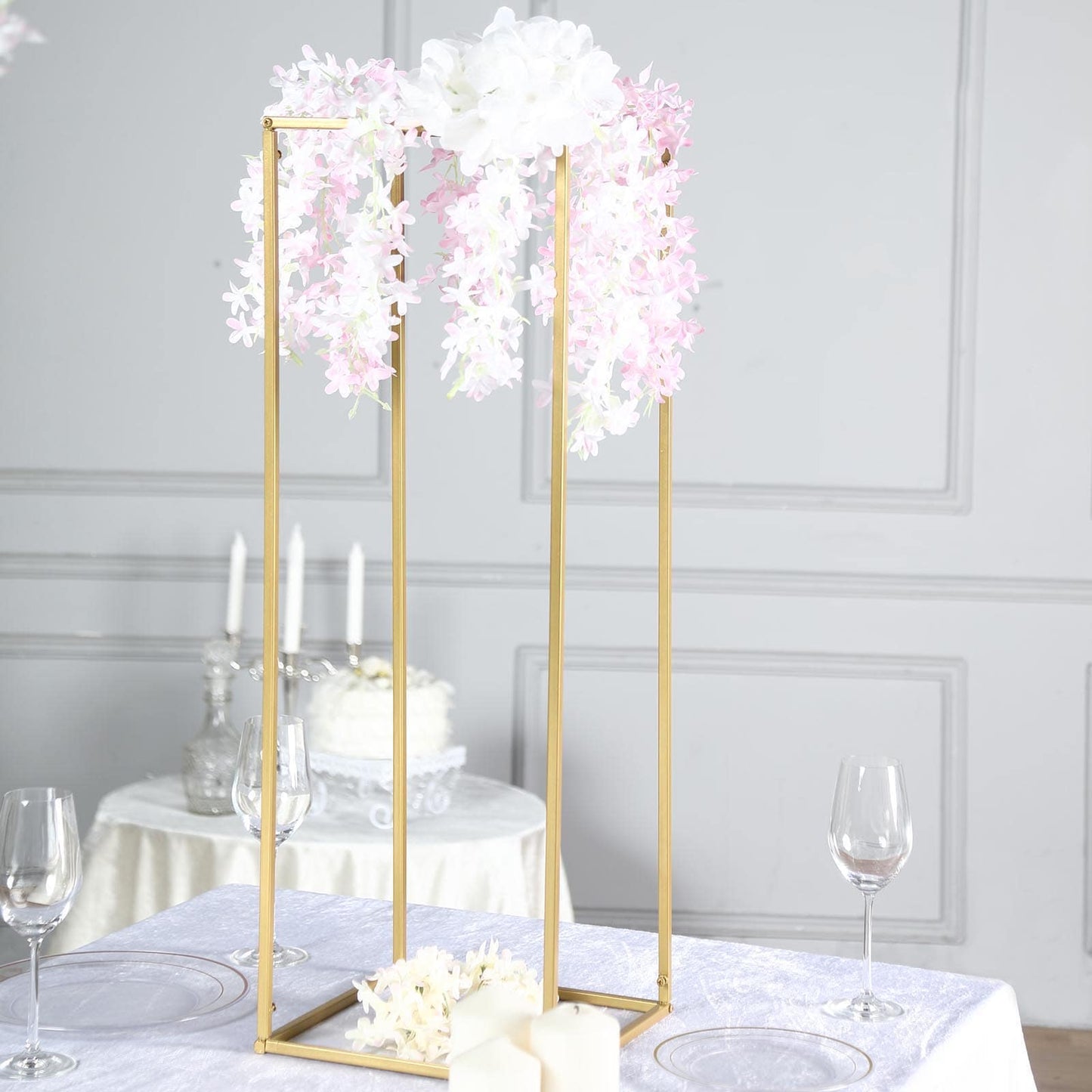 Gold rectangular wedding flower stand with pink floral arrangement.