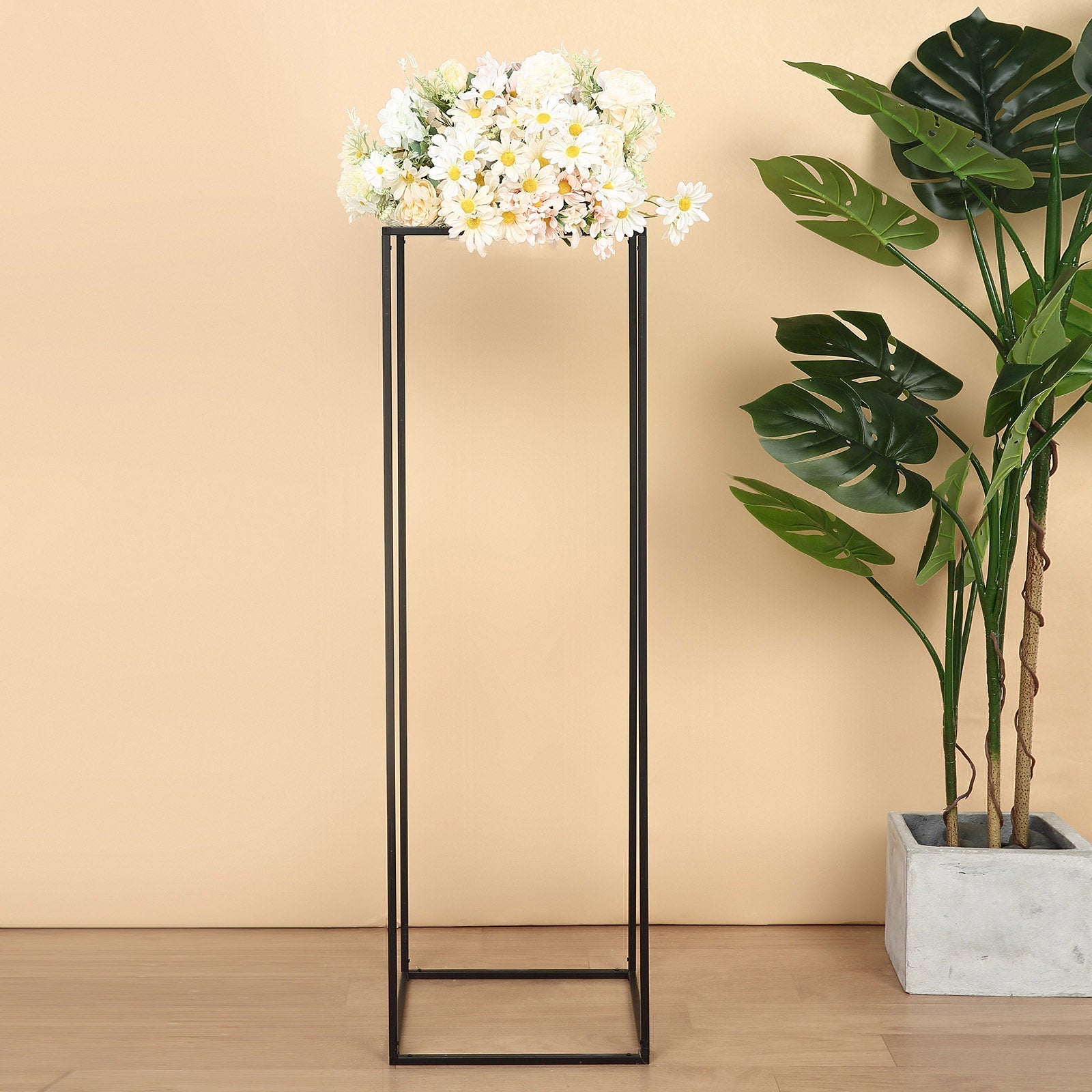 Matte black metal wedding flower stand with white flowers on top.