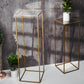 Clear acrylic sheets on display in gold plant stands with greenery.