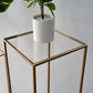 Clear acrylic square plexiglass sheets on a gold frame table.