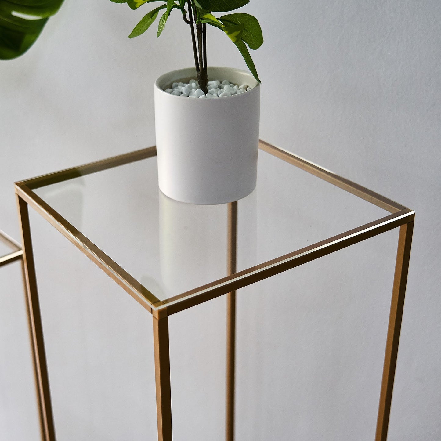 Clear acrylic square plexiglass sheets on a gold frame table.