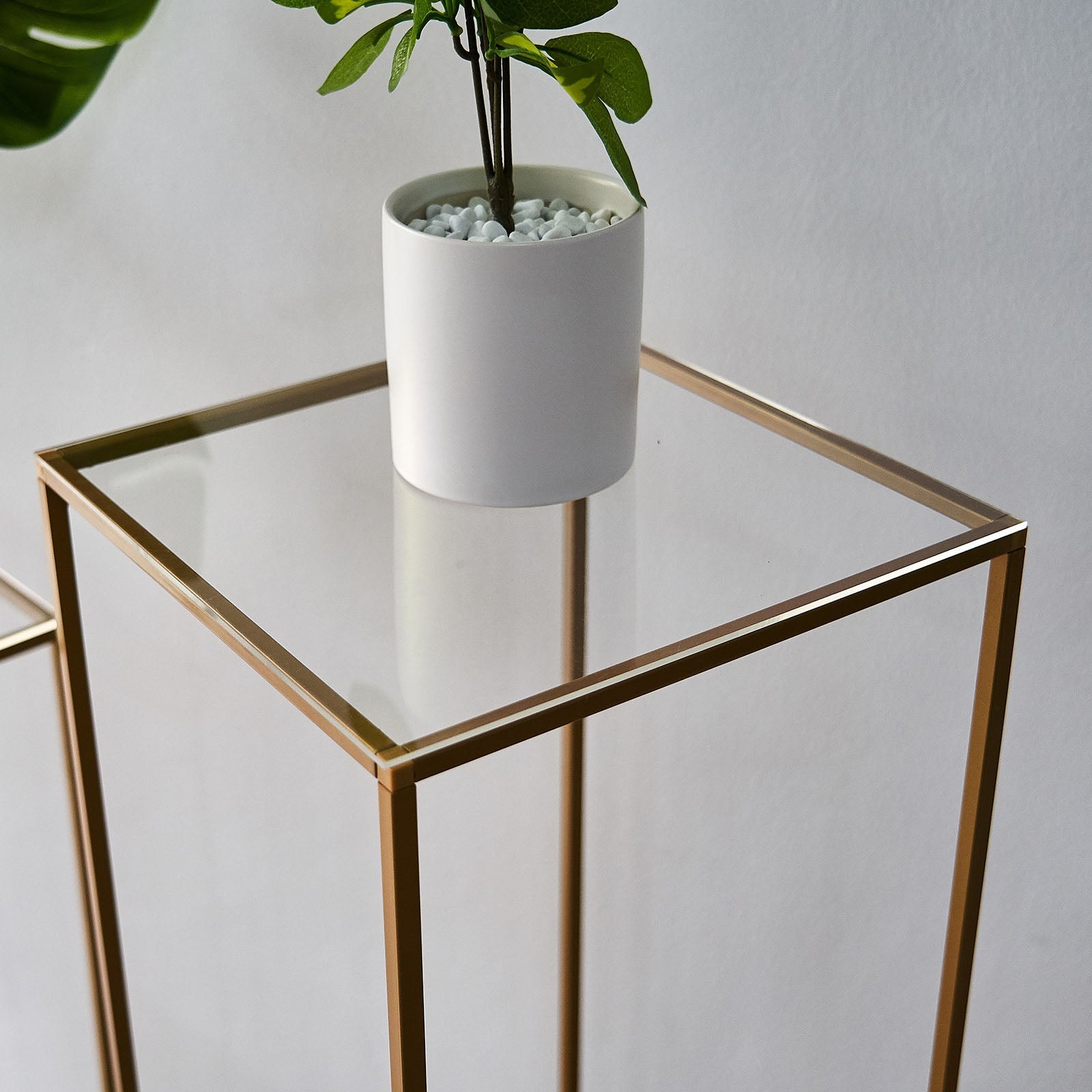 Clear acrylic square plexiglass sheets on a gold frame table.