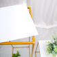 White acrylic square plexiglass sheets on a yellow table with greenery.
