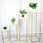 White acrylic square plexiglass sheets displayed on gold plant stands.