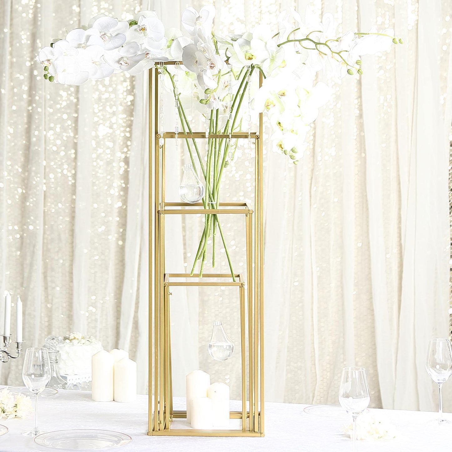 Matte gold metal frame flower stand centerpiece with elegant white orchids.