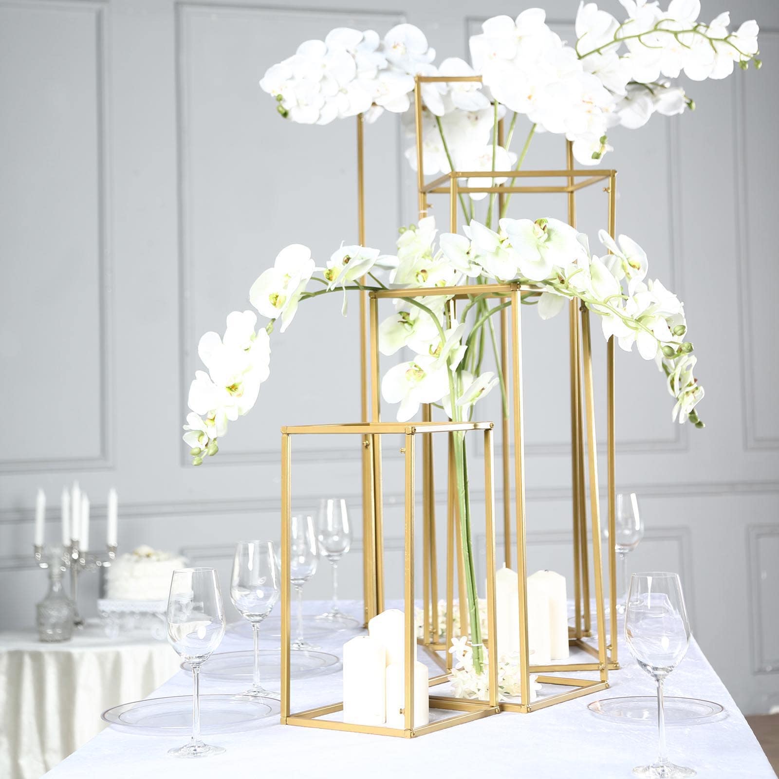 Matte gold metal frame flower stands with white flowers, elegant wedding centerpieces.