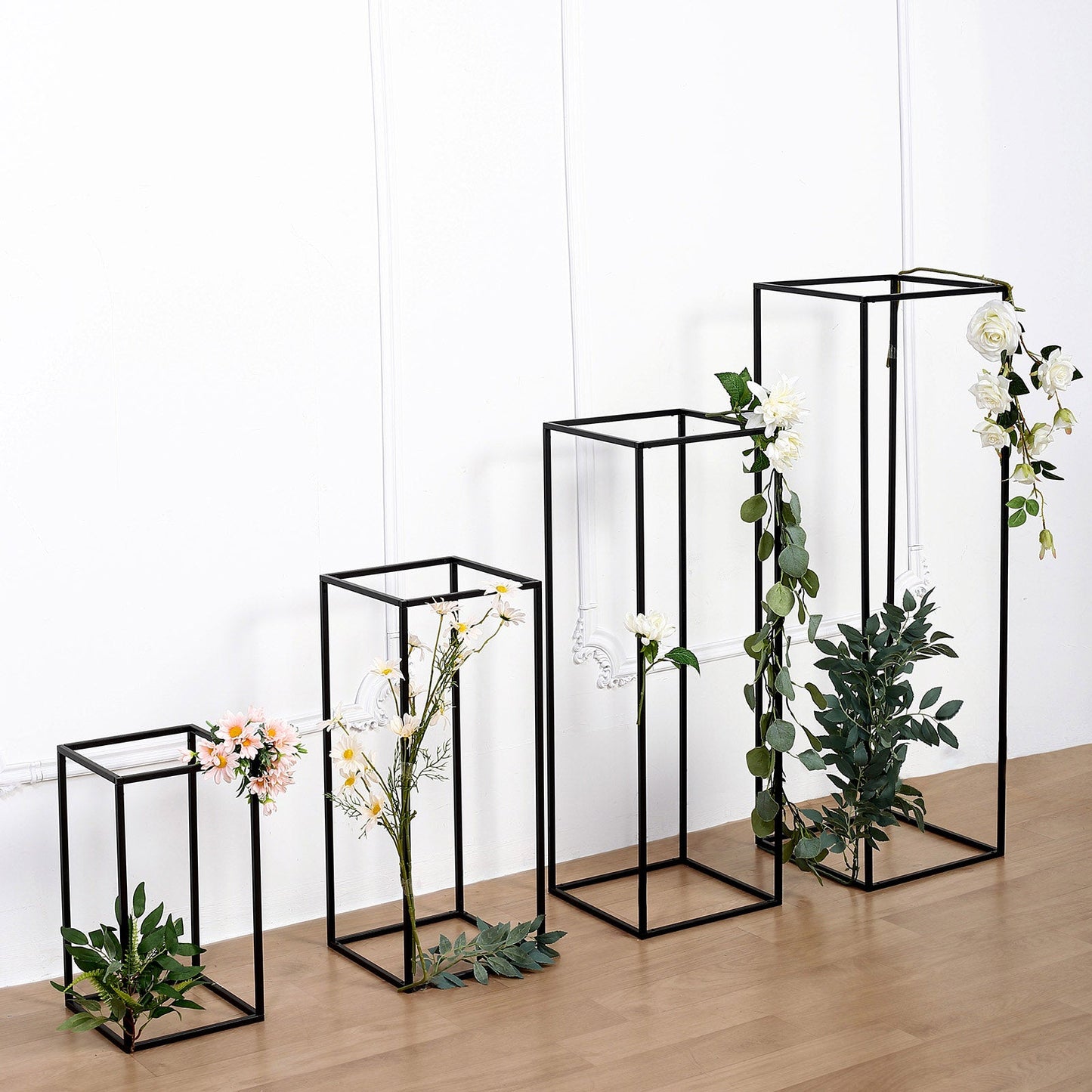Matte black metal frame flower stands in various heights with floral accents.
