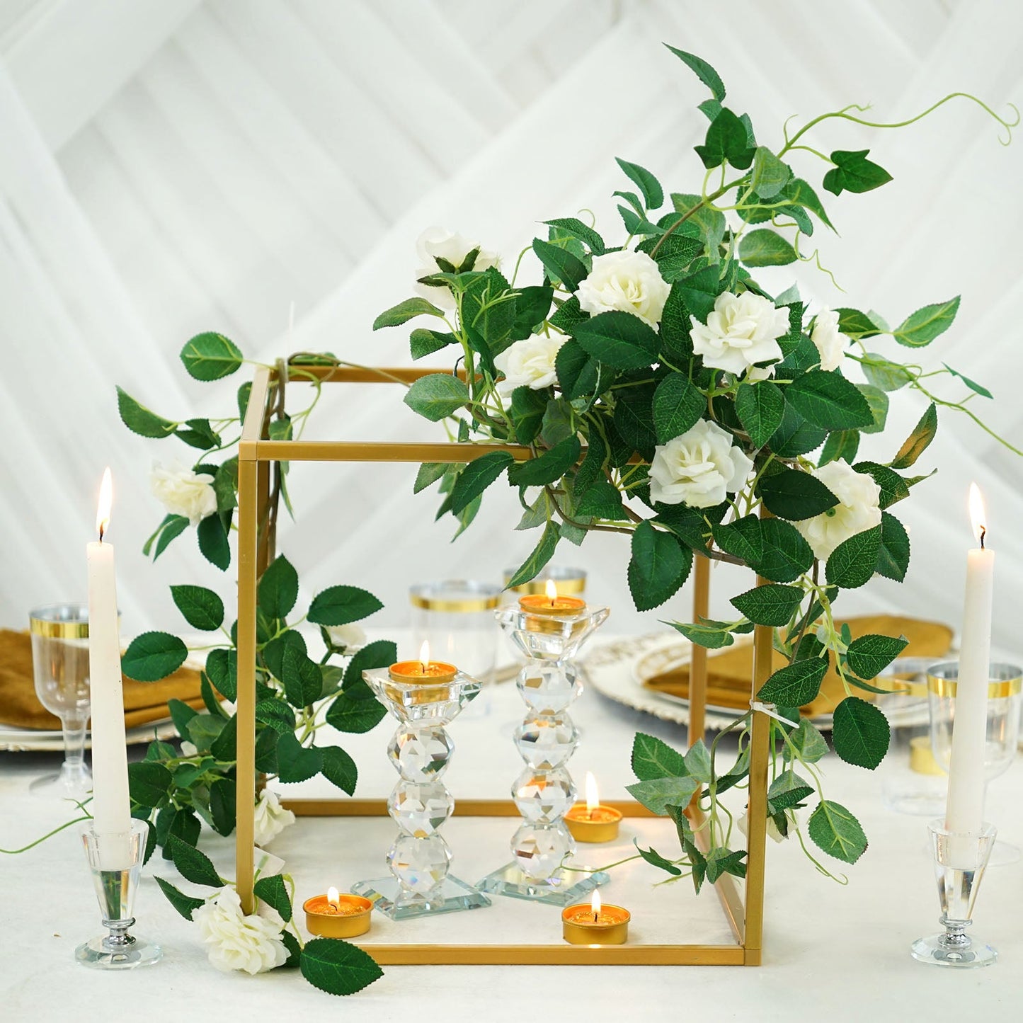 Gold metal frame wedding flower stand with greenery and white roses.