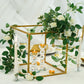 Gold metal frame geometric centerpiece with flowers and candles.