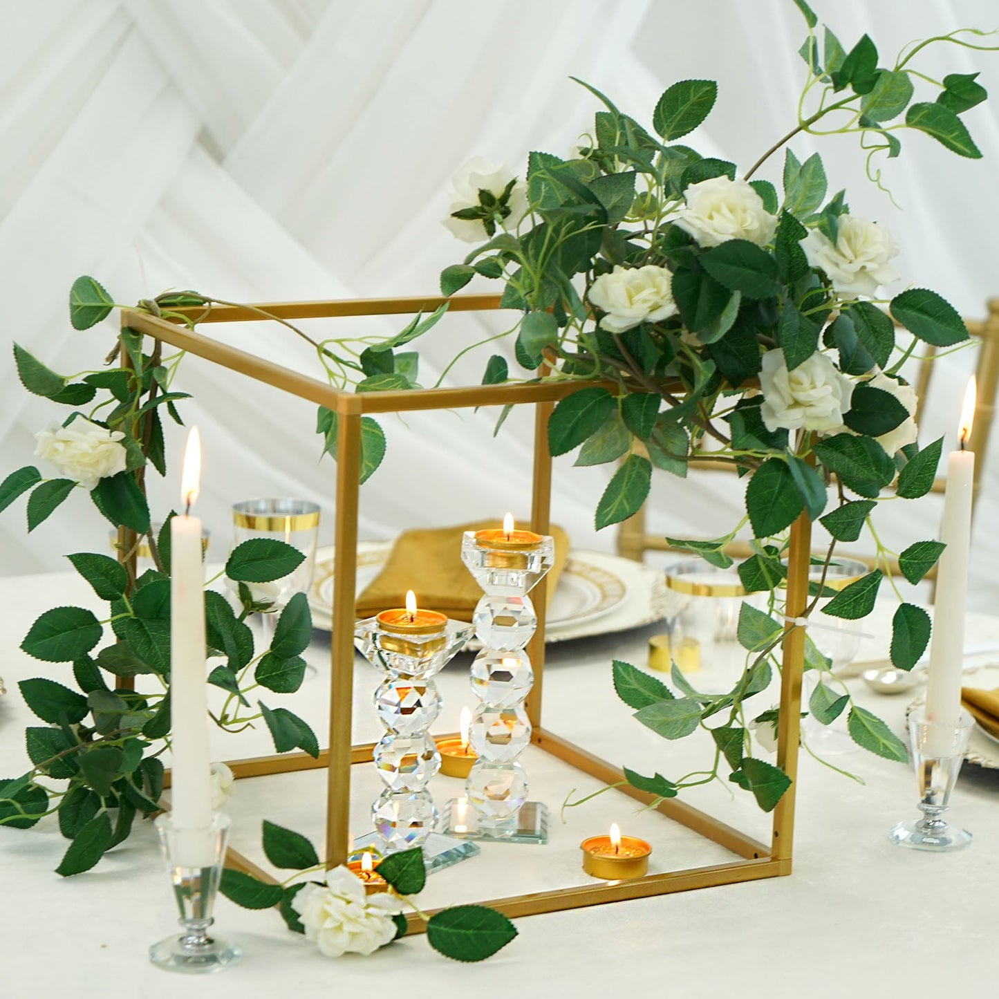 Gold metal frame geometric centerpiece with flowers and candles.