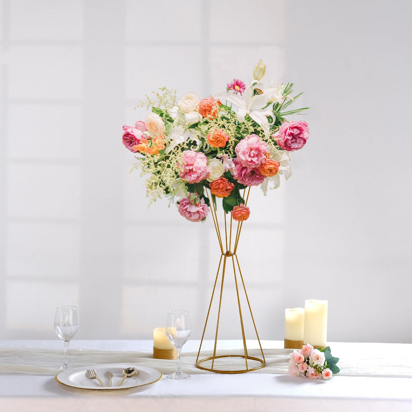 Gold metal geometric flower stand with vibrant floral arrangement.