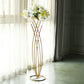 Gold metal mermaid tail flower frame table centerpiece with white floral display.