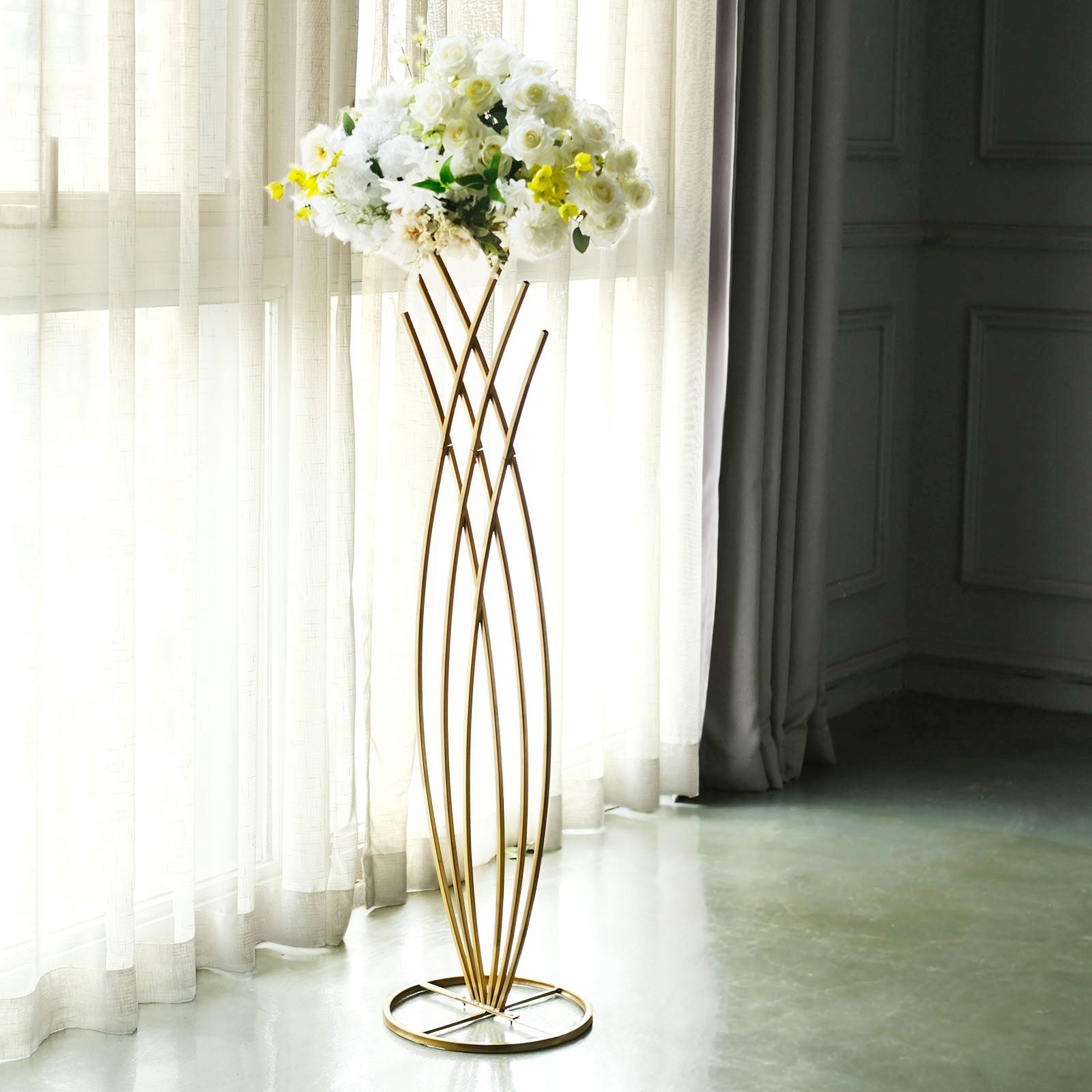 Gold metal mermaid tail flower frame table centerpiece with white floral display.