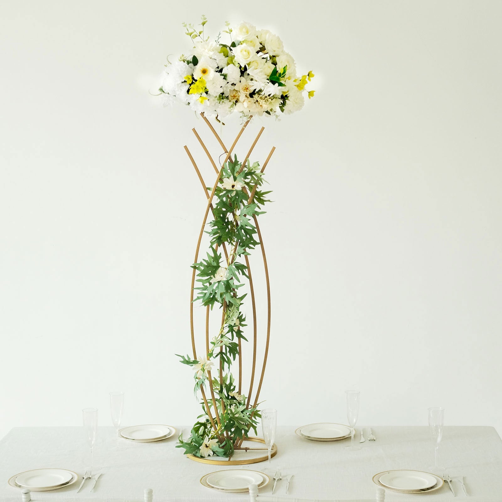 Gold metal mermaid tail flower frame centerpiece with white floral display.