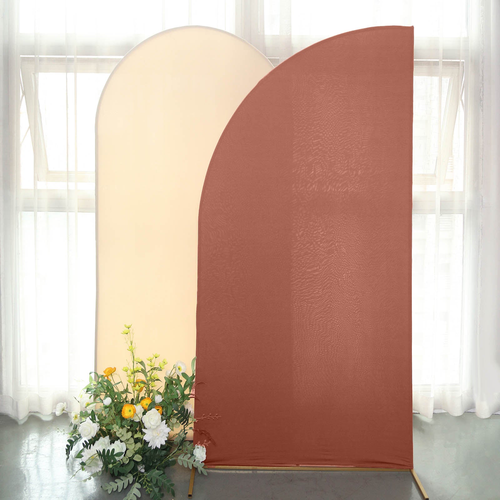 Matte terracotta fitted spandex half moon wedding arch cover with floral arrangement.