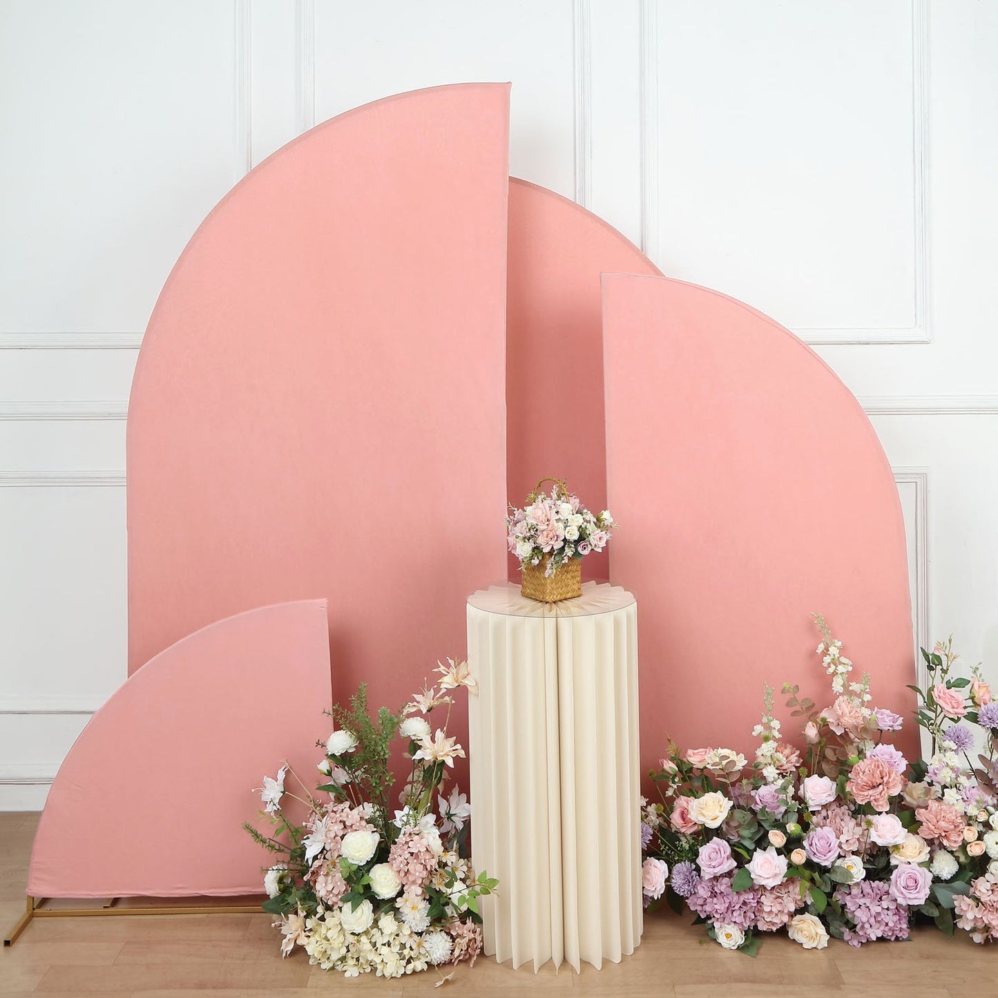 Matte dusty rose spandex half moon backdrop stand covers with floral arrangements.