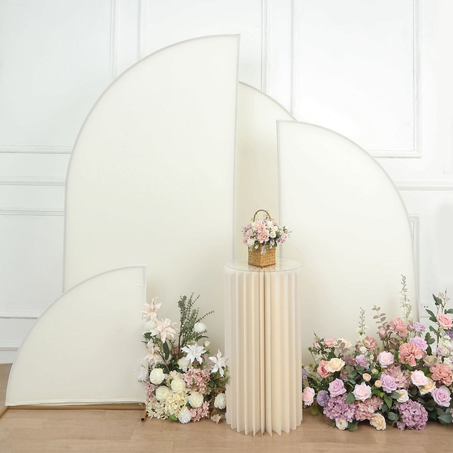 Matte ivory spandex half moon backdrop stand covers with floral arrangements.