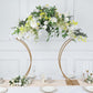 Gold floral arch frame centerpiece with white flowers and greenery.