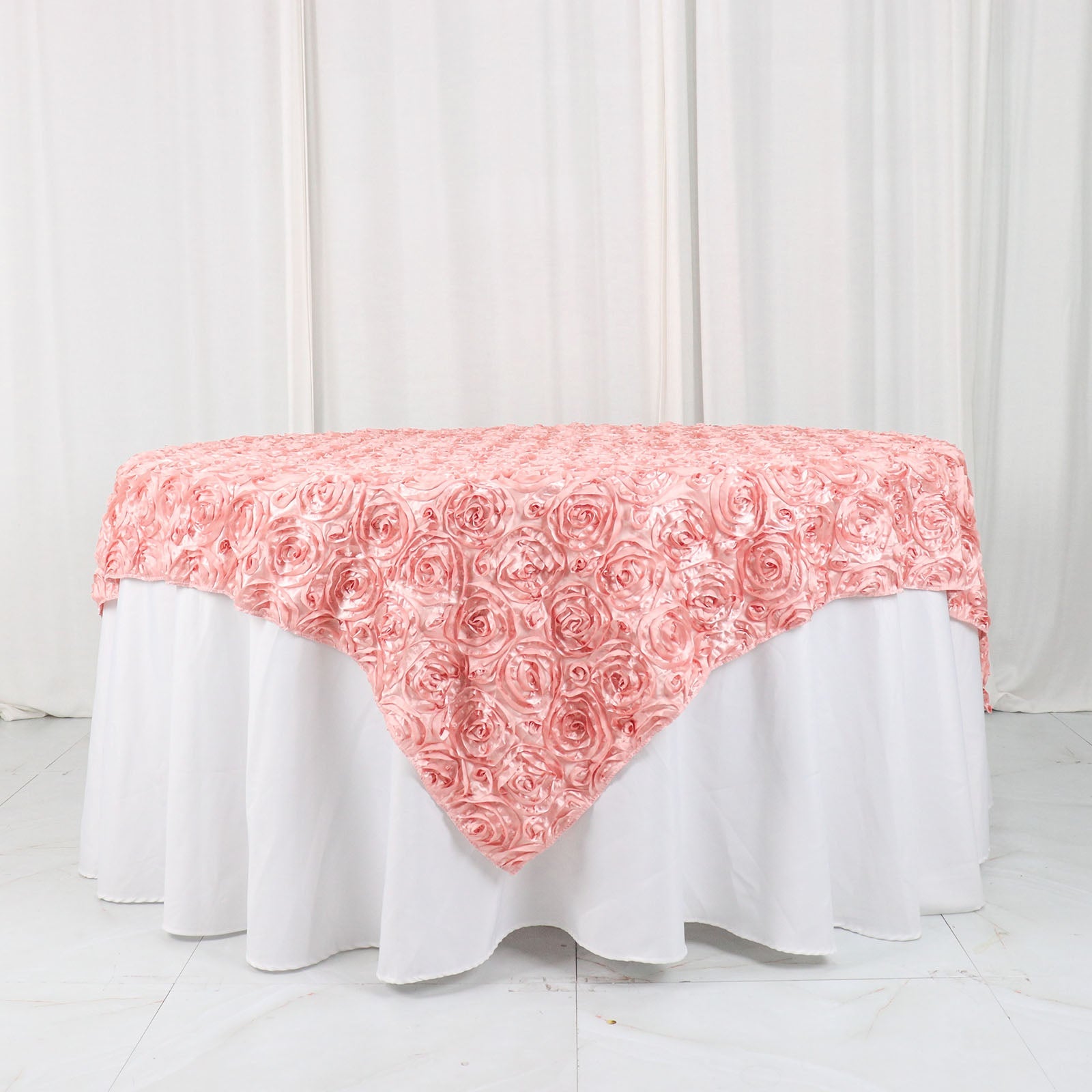 Dusty rose 3D rosette satin table overlay on a white table.