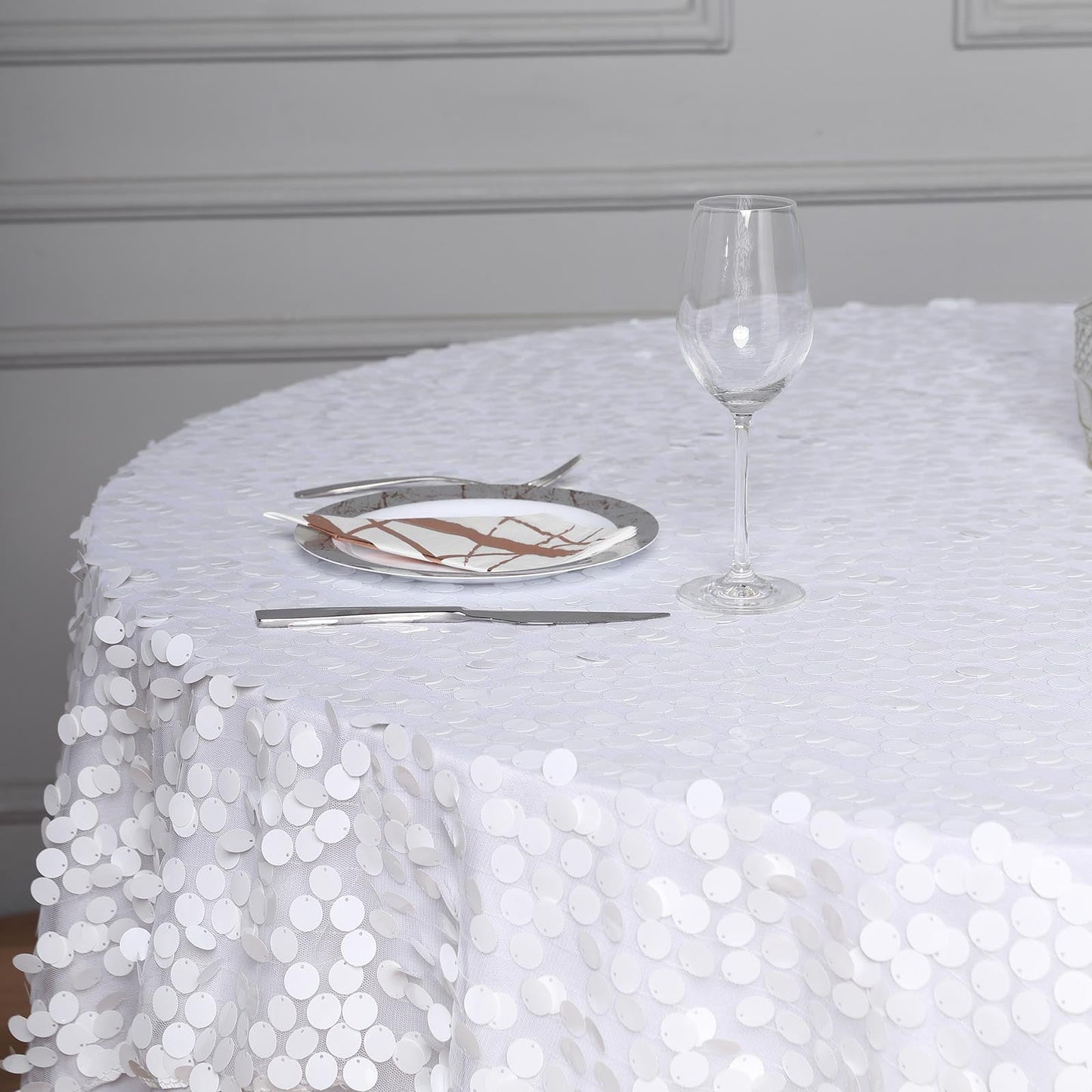 White big Payette sequin square table overlay on a round table setting.