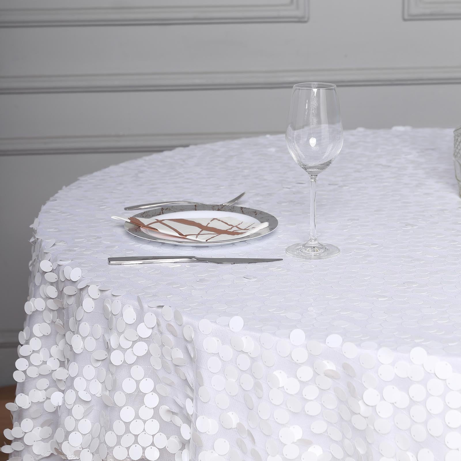 White big Payette sequin square table overlay on a round table setting.