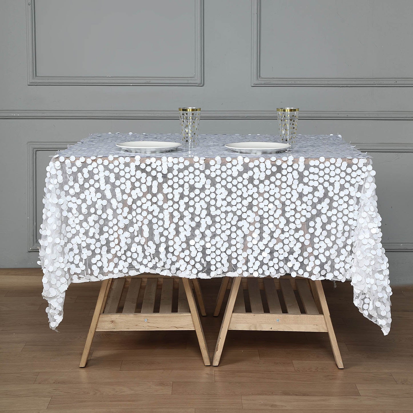 White big Payette sequin square table overlay on a wooden table.
