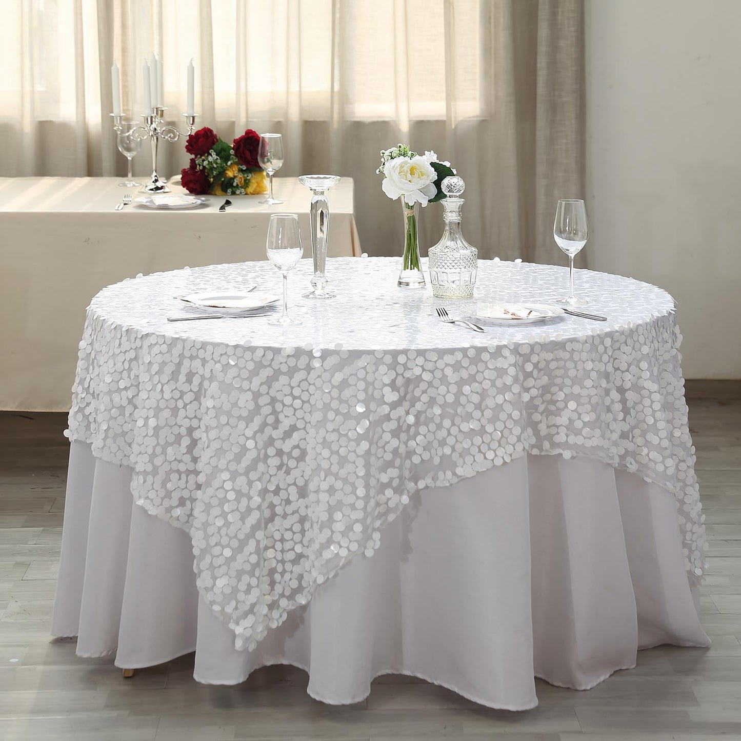White big Payette sequin square table overlay on a round table