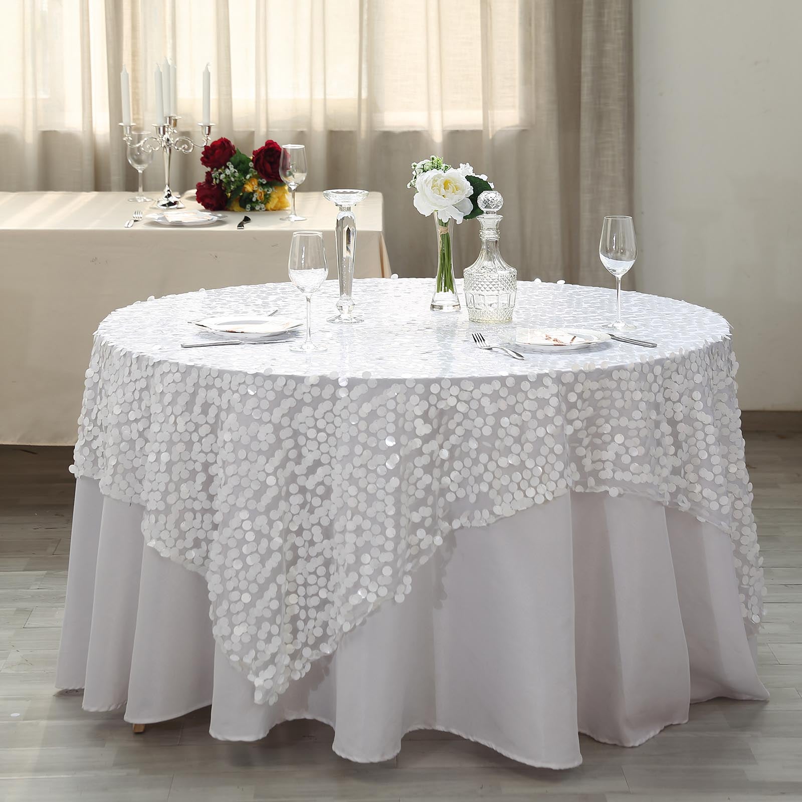 White big Payette sequin square table overlay on a round table