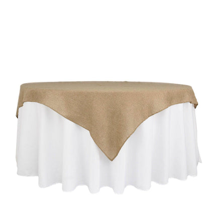 Natural faux jute burlap square table overlay on a white tablecloth.