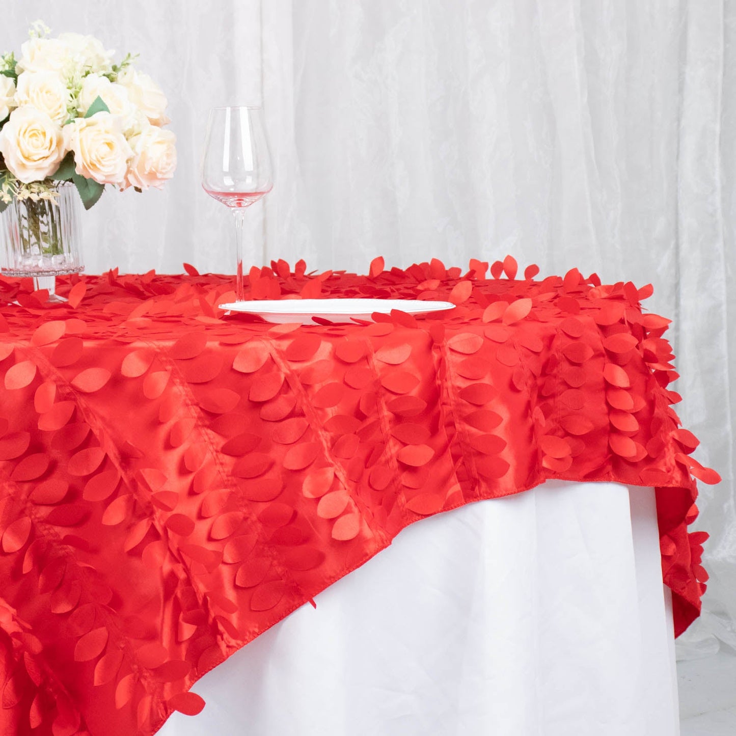 Red 3D leaf petal taffeta fabric table overlay on a white table.