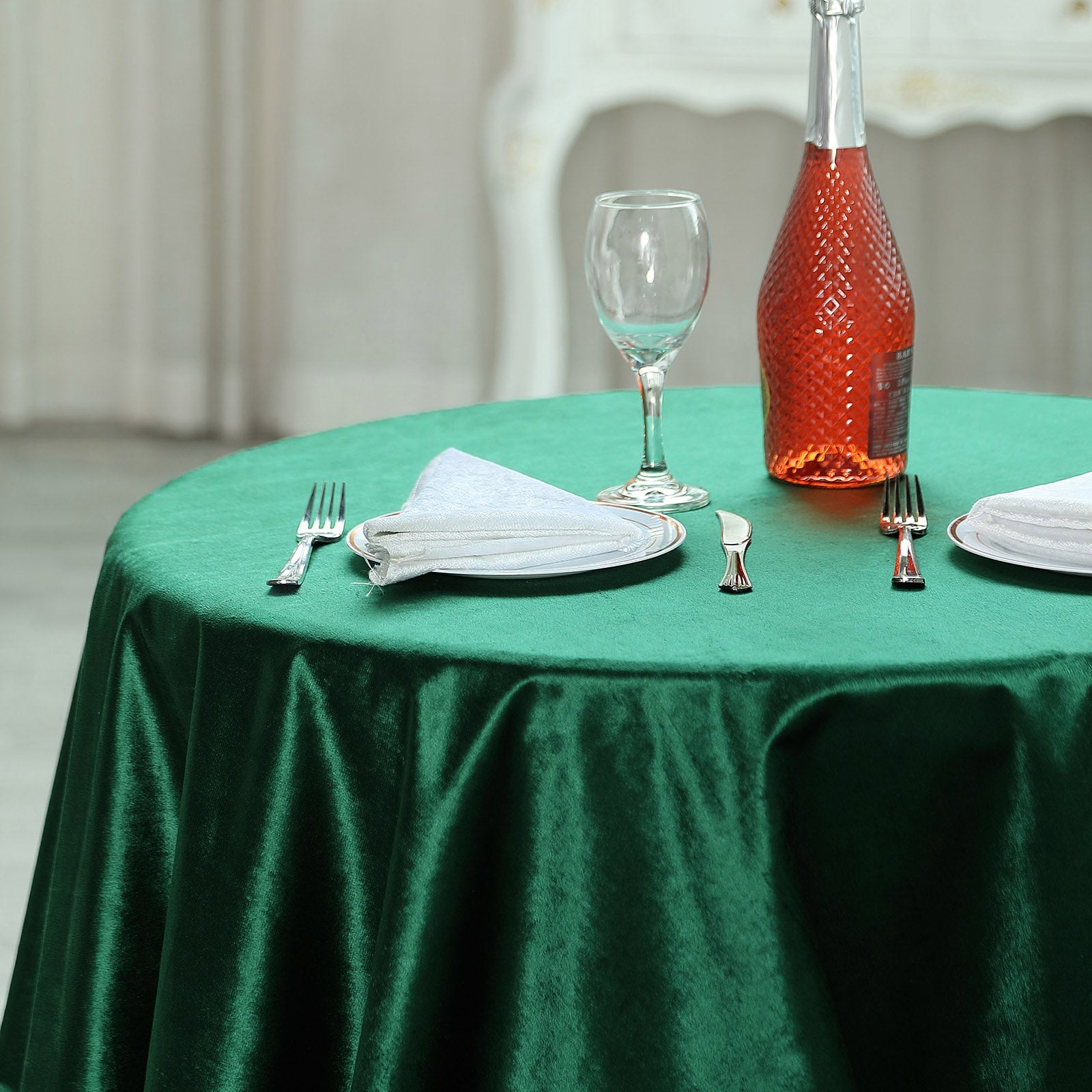Hunter emerald green velvet table overlay on a round table setting.