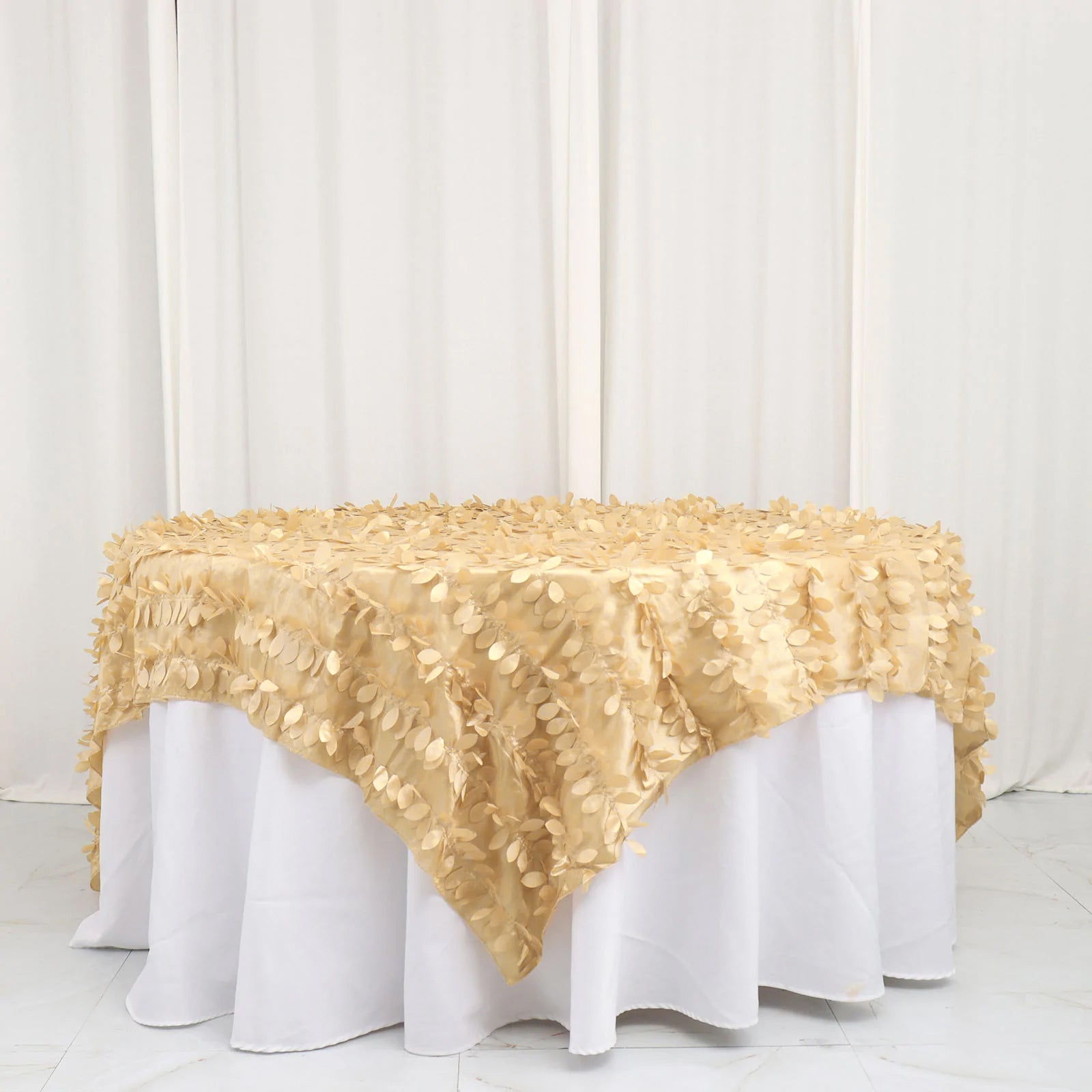 Champagne leaf petal taffeta table overlay on a round table.
