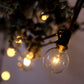 Warm white connectable string lights with glass bulbs, perfect for indoor or outdoor use.
