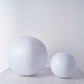 White inflatable garden glow balls on a wooden surface.
