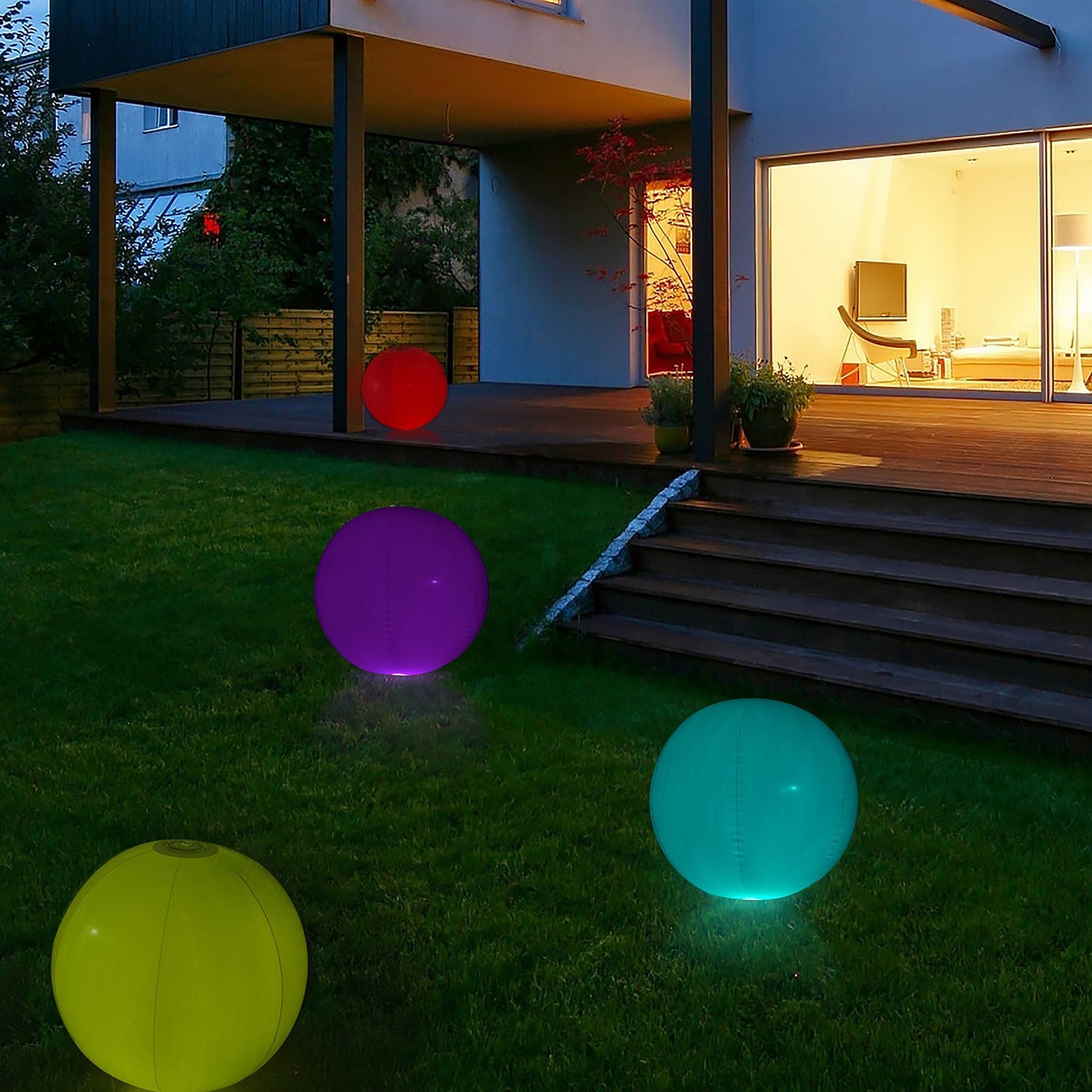 Colorful inflatable glow balls in a garden, featuring purple and teal lights.
