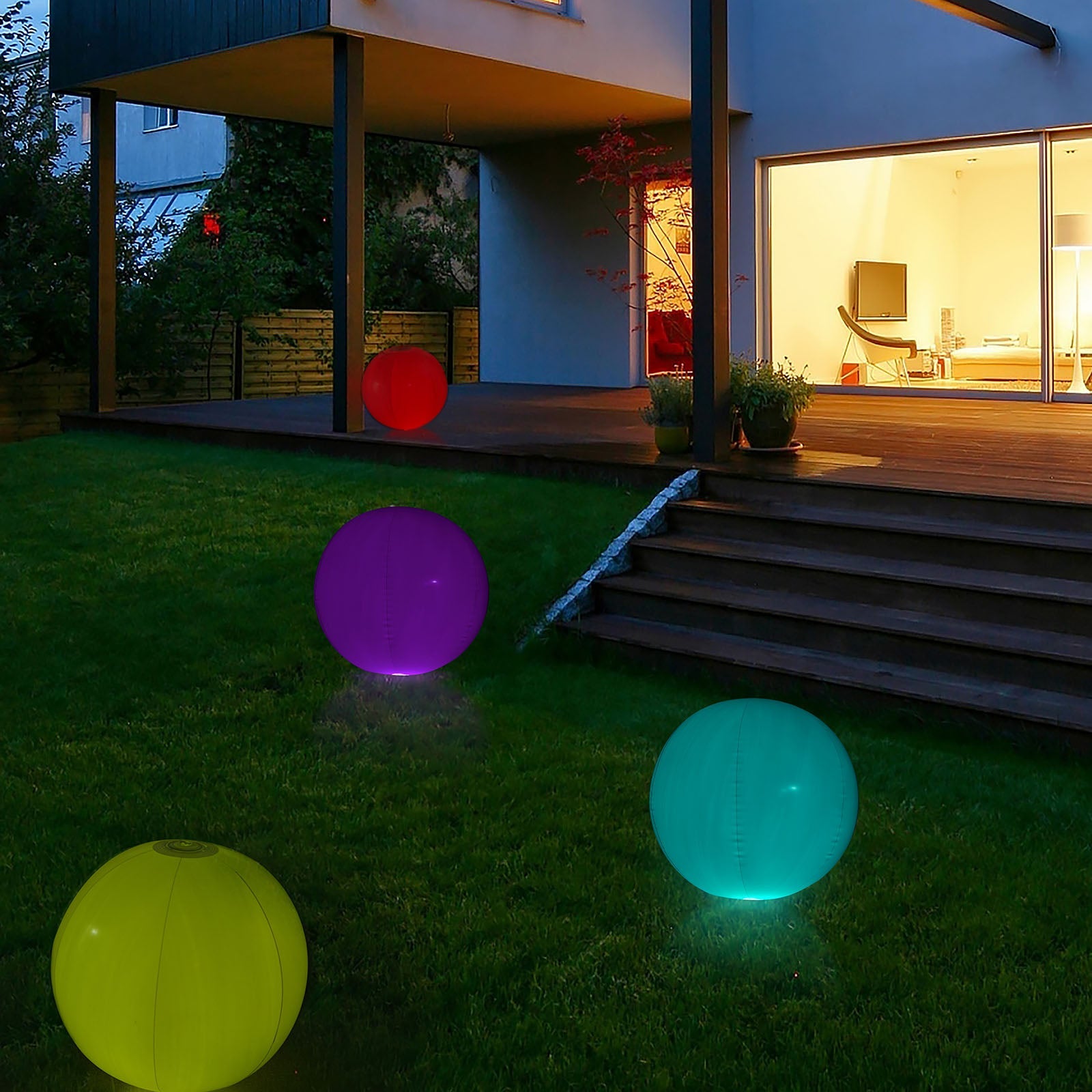 Colorful inflatable glow balls in a garden, featuring purple and teal lights.