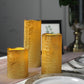 Metallic gold LED pillar candles set of 3, flameless and remote-operated.
