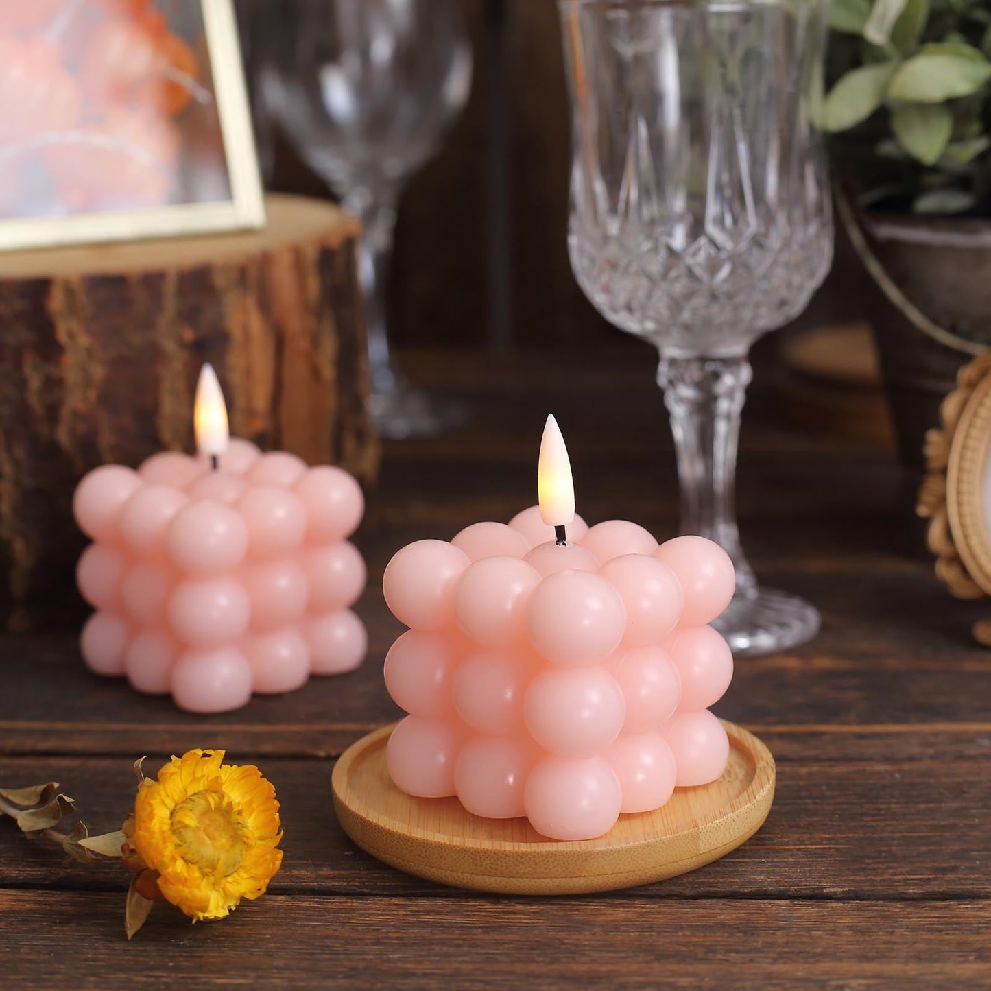Warm white bubble candles in a soft blush color on a wooden surface.