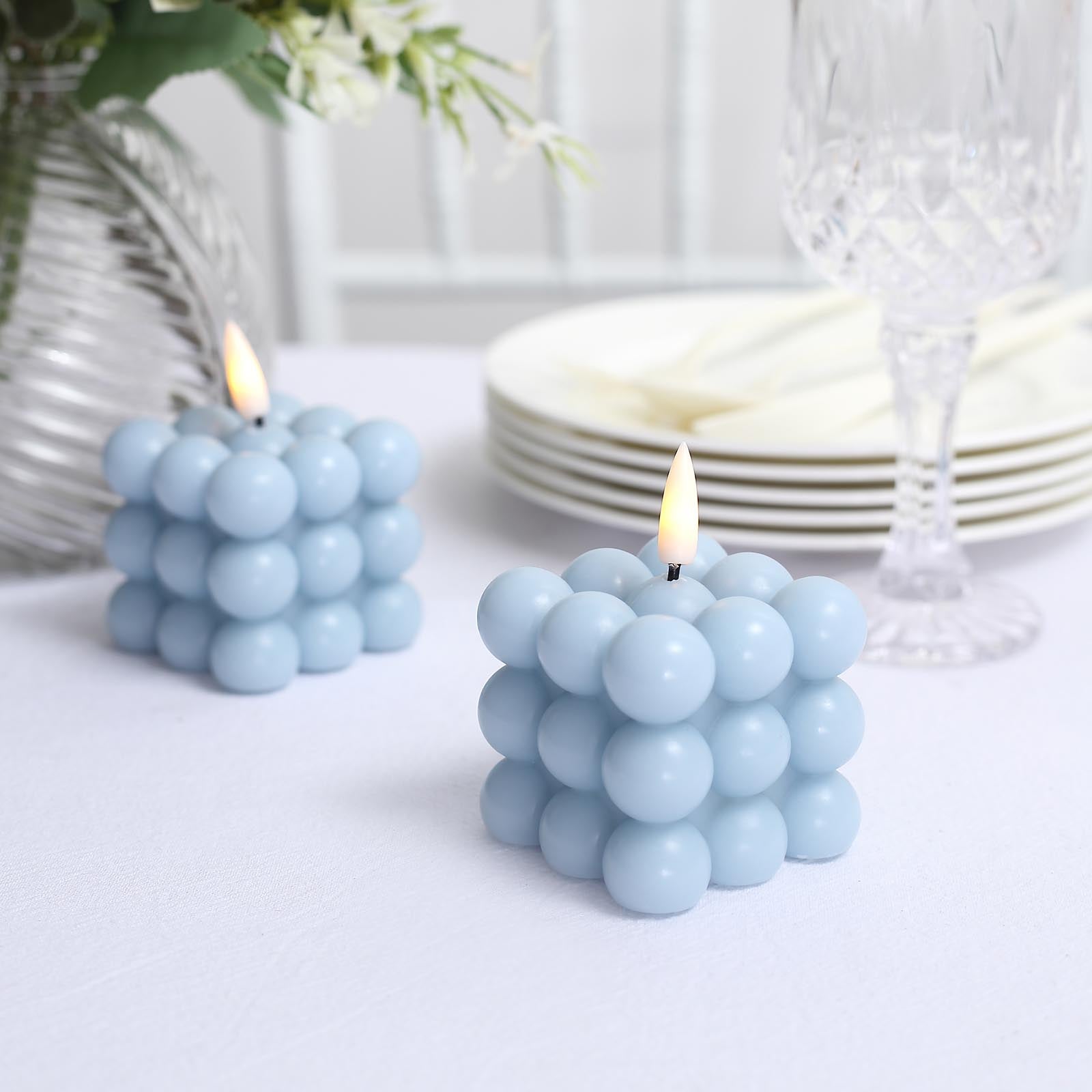 Dusty blue LED bubble candles on a table setting.