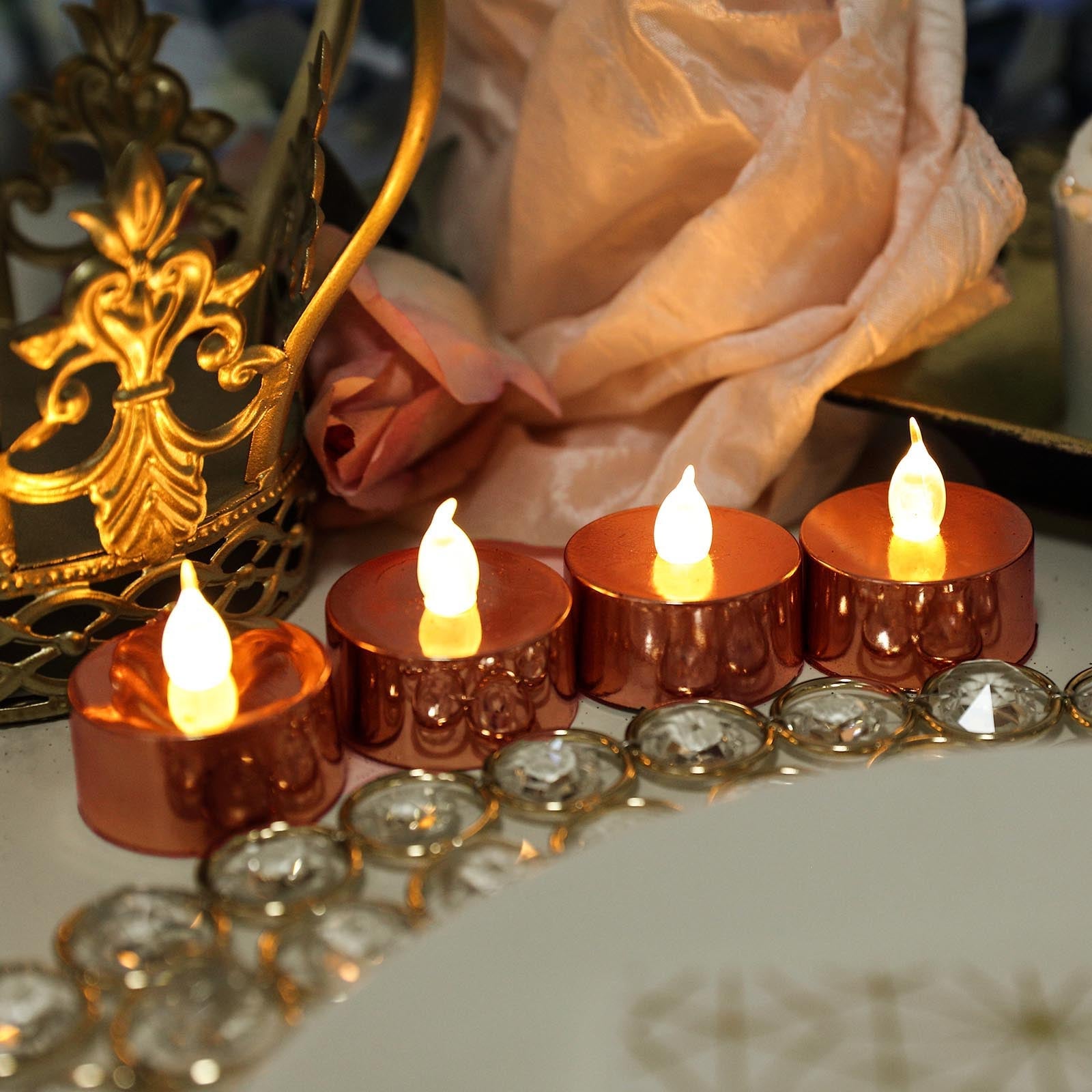 Metallic rose gold LED tealight candles with flickering flames.