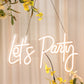 23" Let's Party neon light sign in warm white with floral decor.
